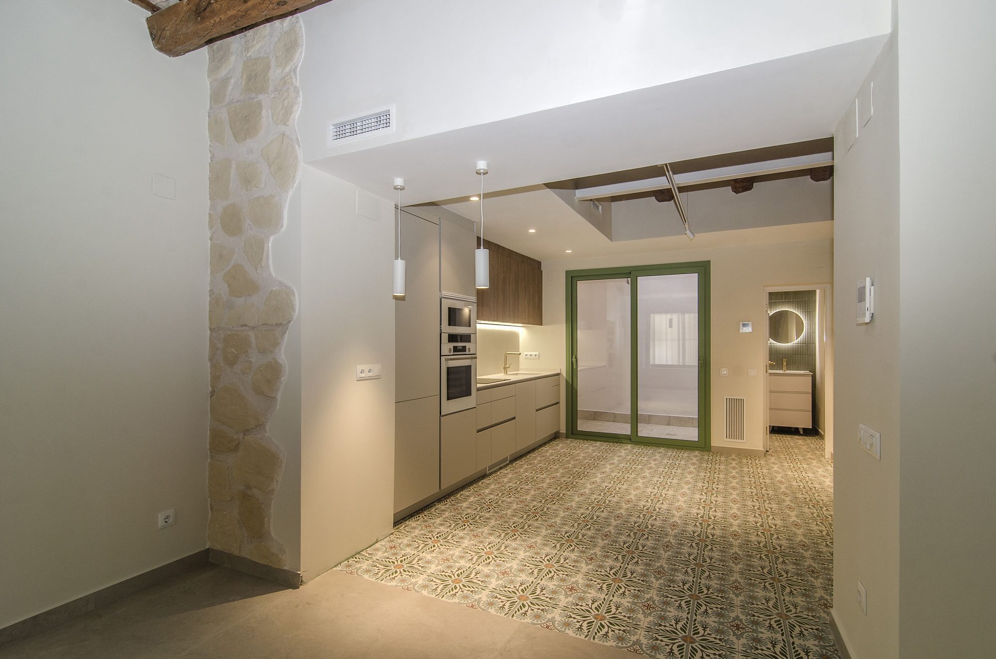 Cocina rehabilitada con suelo de mosaico hidráulico y columna de piedra