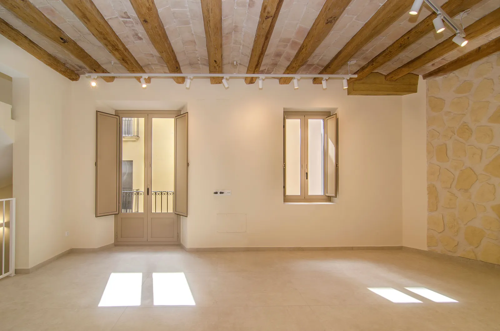 Salón con vigas de madera originales en la rehabilitación de Carrer Fossar Vell, Vilanova i la Geltrú