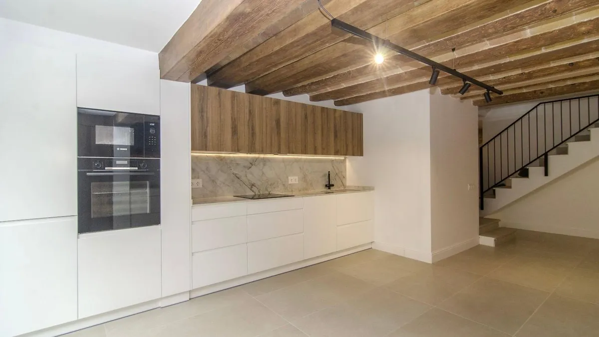 Rehabilitación de vivienda en Carrer Major, Vilanova i la Geltrú — cocina con bóveda catalana y vigas de madera